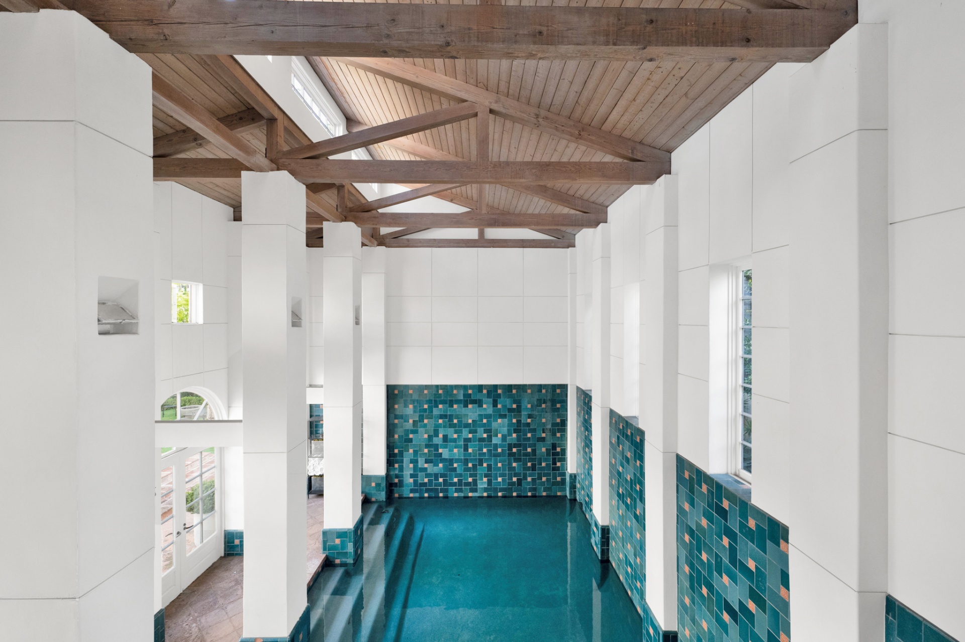 Overhead view of the indoor pool showing wooden truss ceiling