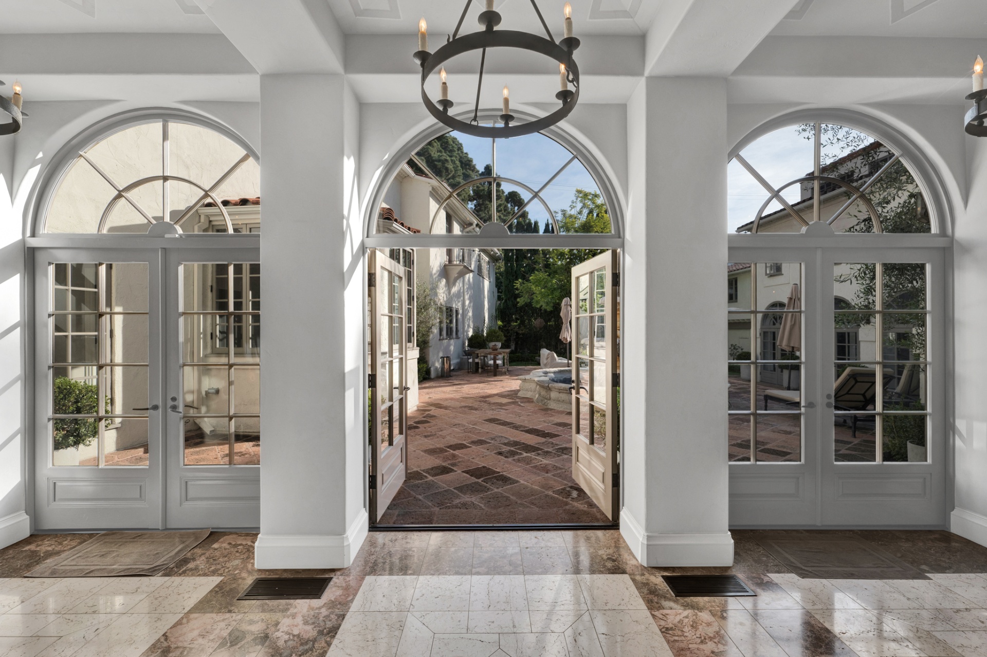 Triple arched French doors opening from the loggia to the courtyard