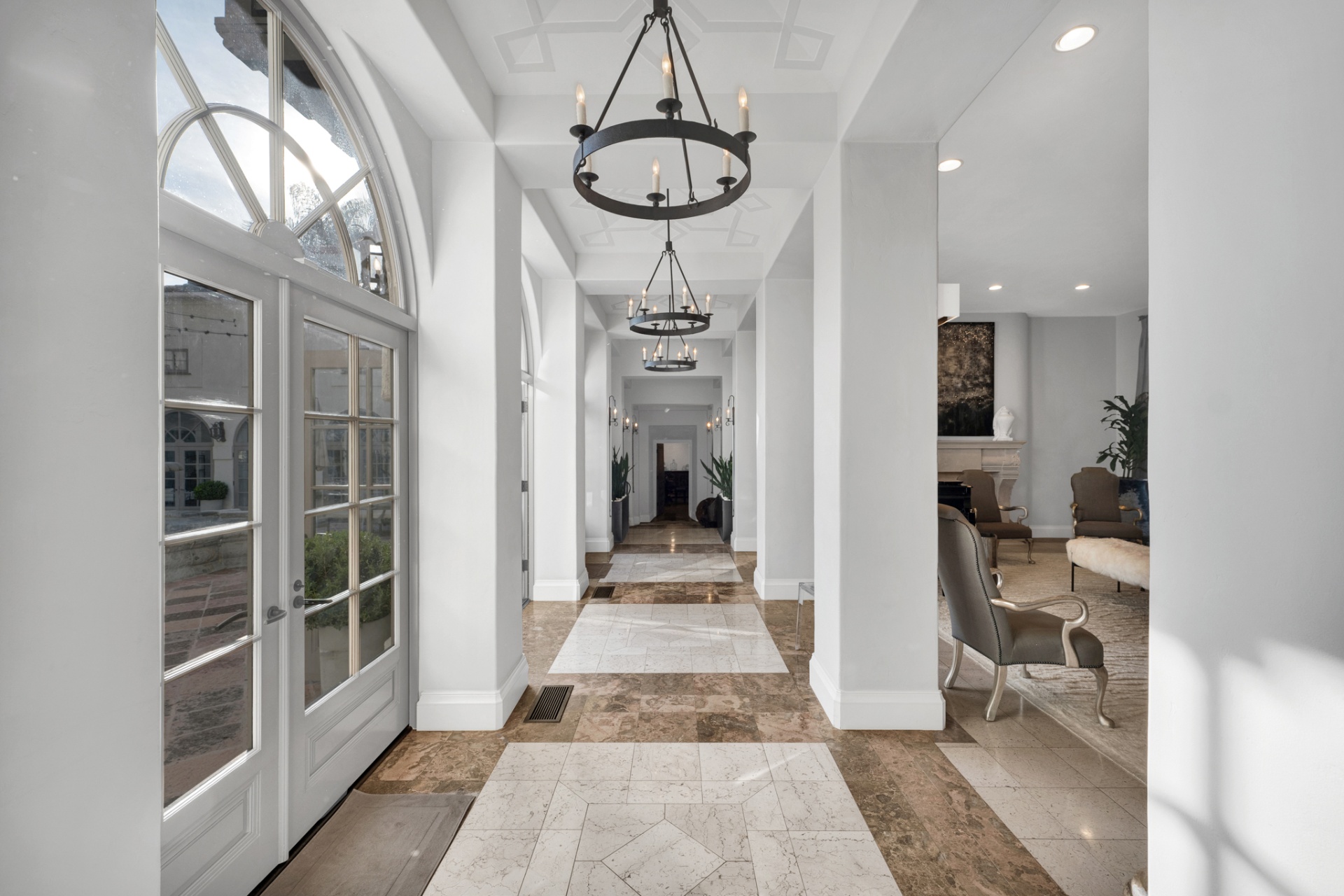 Long marble gallery hallway with wrought-iron chandeliers