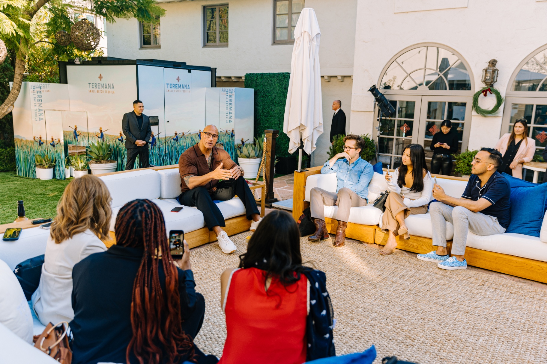 Dwayne Johnson speaking with guests in the courtyard lounge