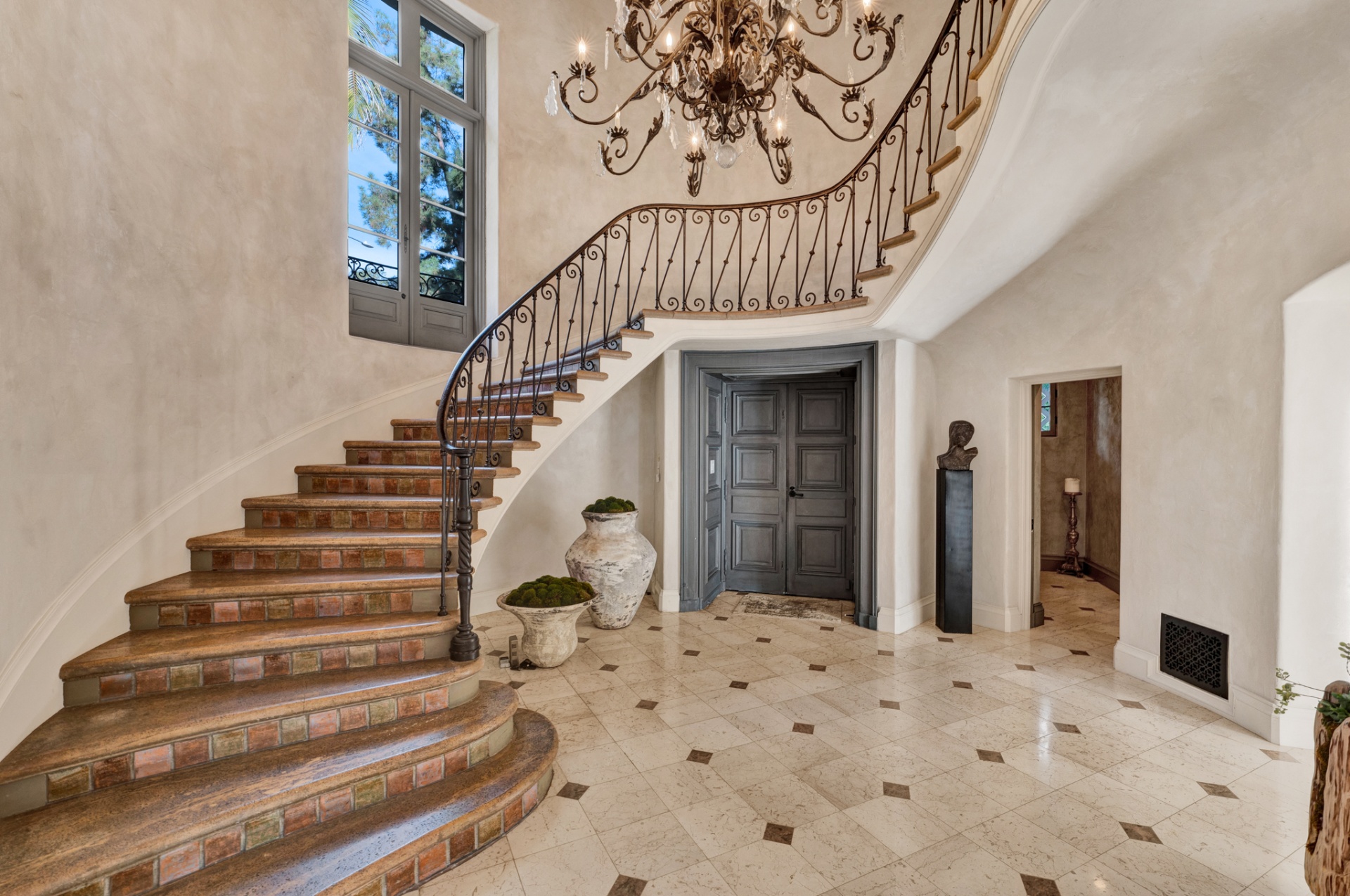 Curved wrought-iron staircase with terracotta tile risers
