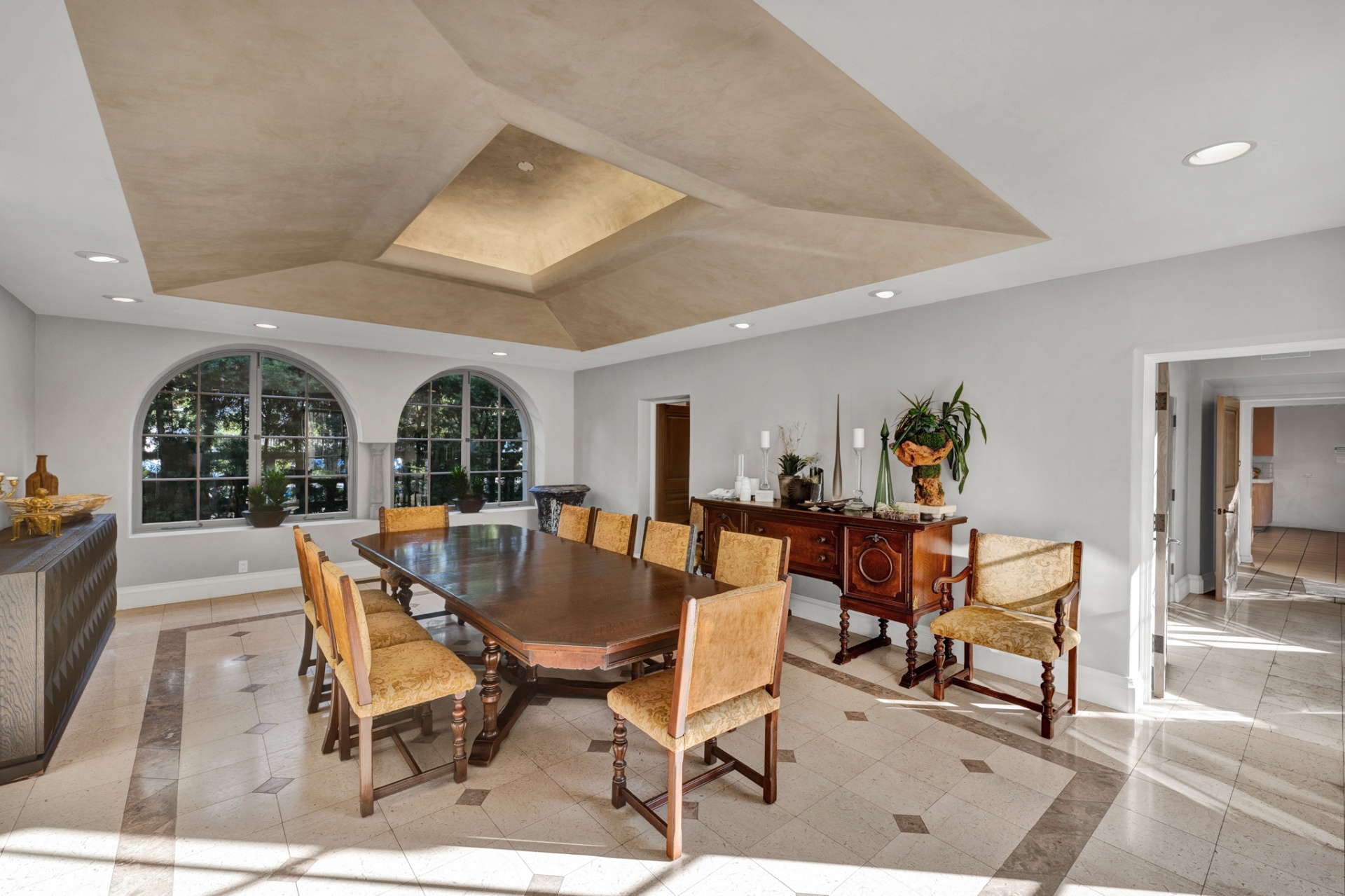 Formal dining room with tray ceiling and arched windows