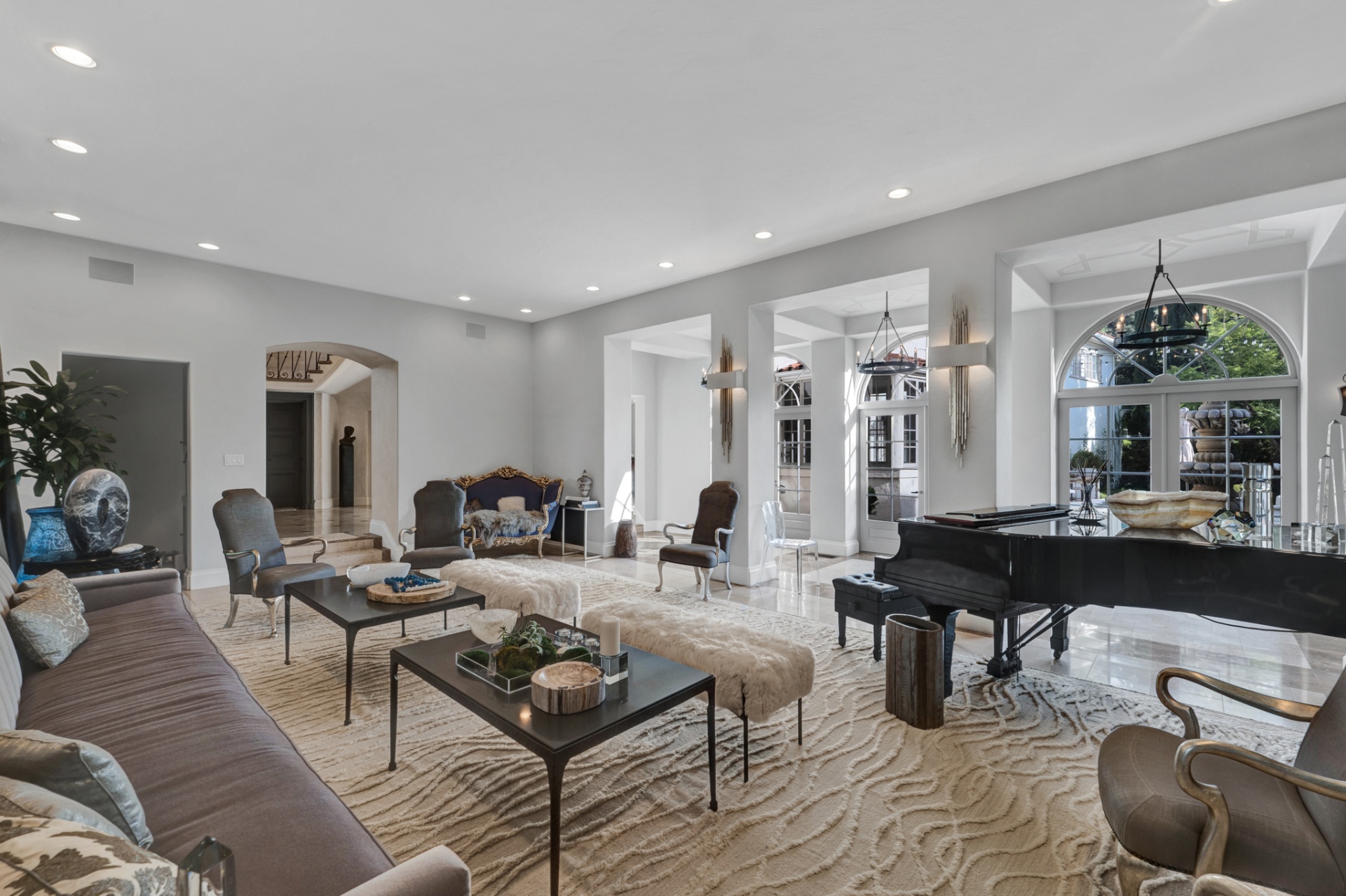 Great room with grand piano and arched French doors onto the courtyard